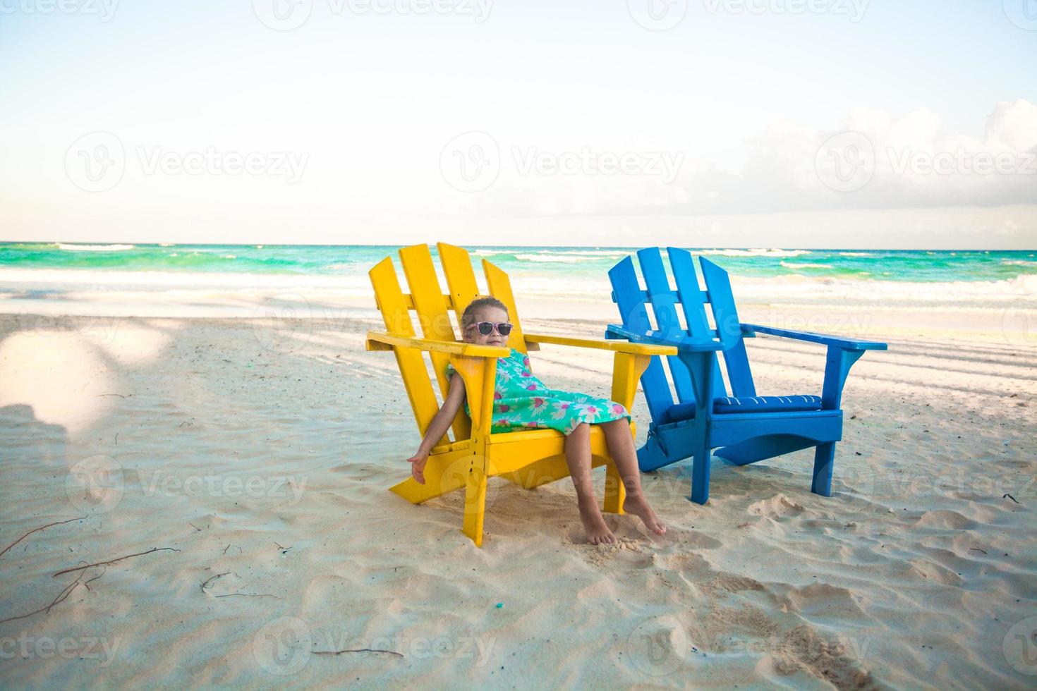 weinig meisje in strand houten kleurrijk stoelen Aan tropisch tulum strand, Mexico foto