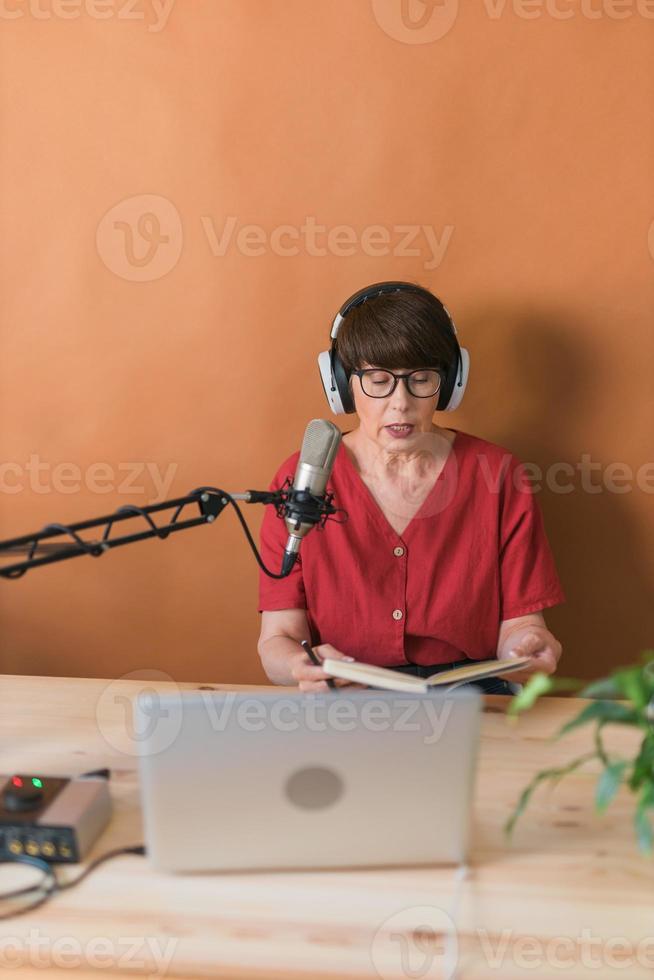 middelbare leeftijd vrouw radio gastheer maken podcast opname voor online tonen - uitzending en dj concept foto