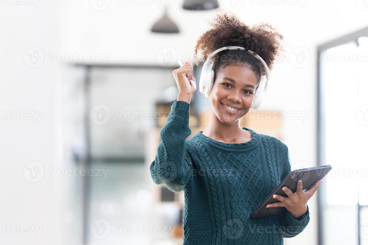 portret van glimlachen jong zwart vrouw luisteren muziek- met koptelefoon en digitaal tablet foto