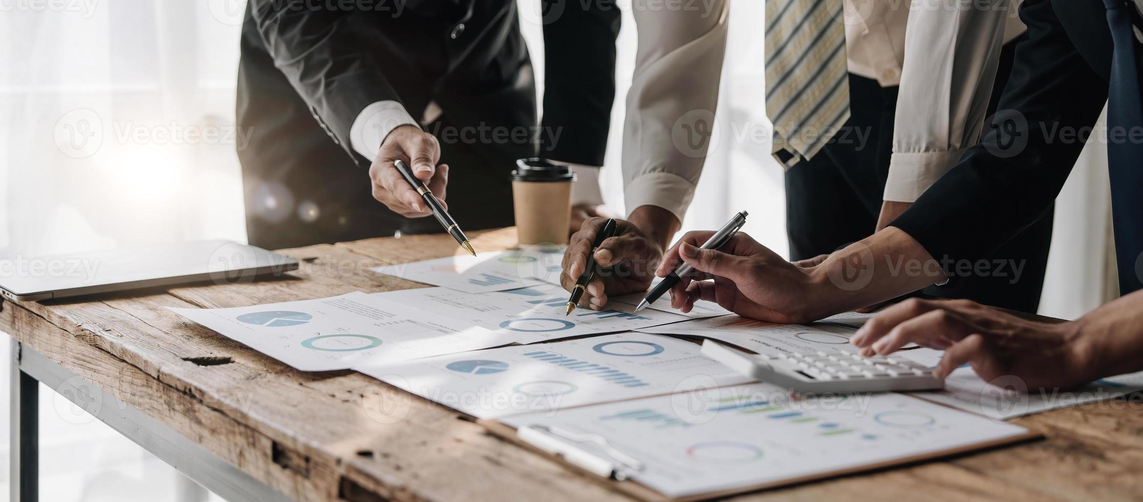 zakenmensen ontmoeten elkaar met behulp van laptopcomputer, rekenmachine, notebook, beursgrafiekpapier voor analyseplannen om de kwaliteit volgende maand te verbeteren. conferentie discussie bedrijfsconcept foto