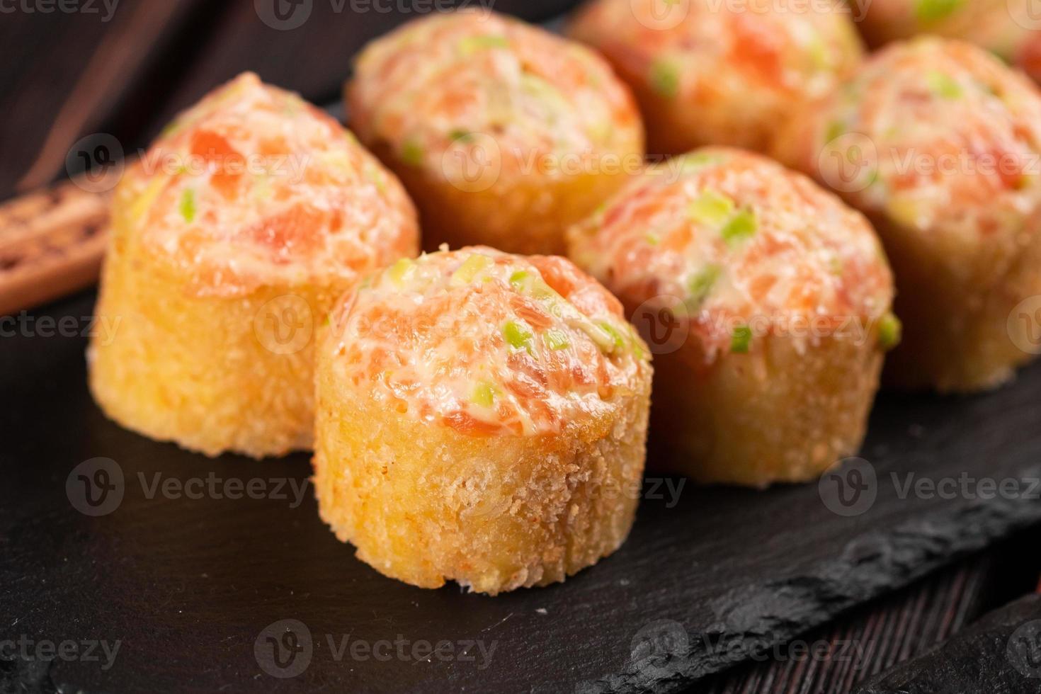 sushi rollen met mayonaise saus geserveerd Aan zwart bord en soja saus detailopname foto