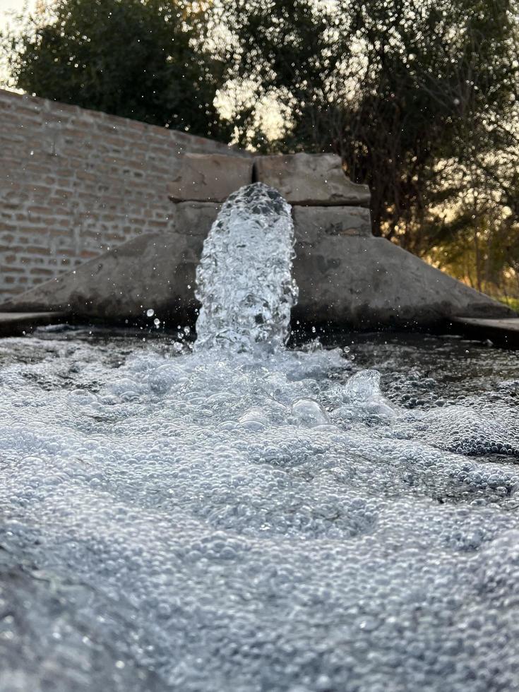 irrigatie water stromen van pijp naar kanaal voor landbouw velden foto