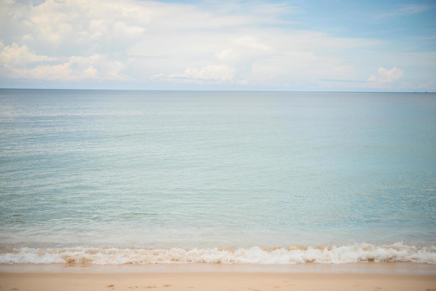 blauwe oceaan en zandstrand achtergrond foto
