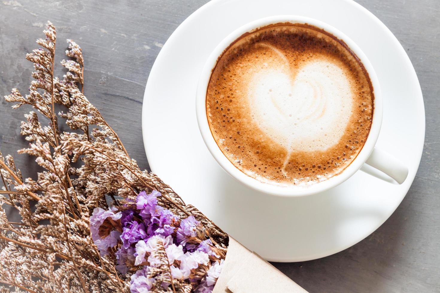 latte en bloemen op een grijze tafel foto