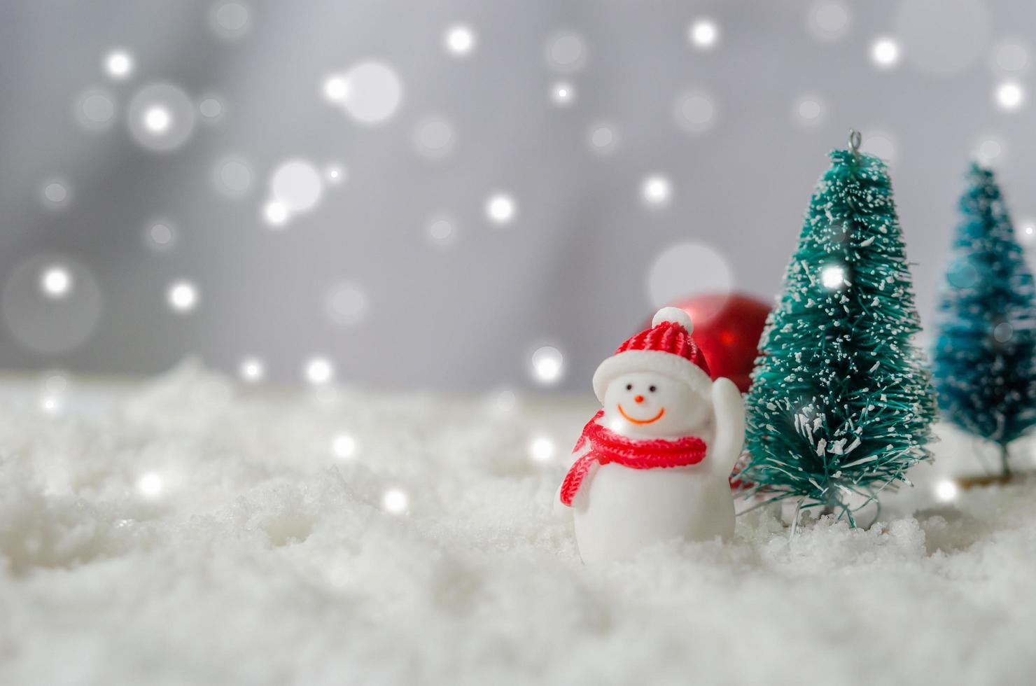 miniatuursneeuwman en kerstbomen foto