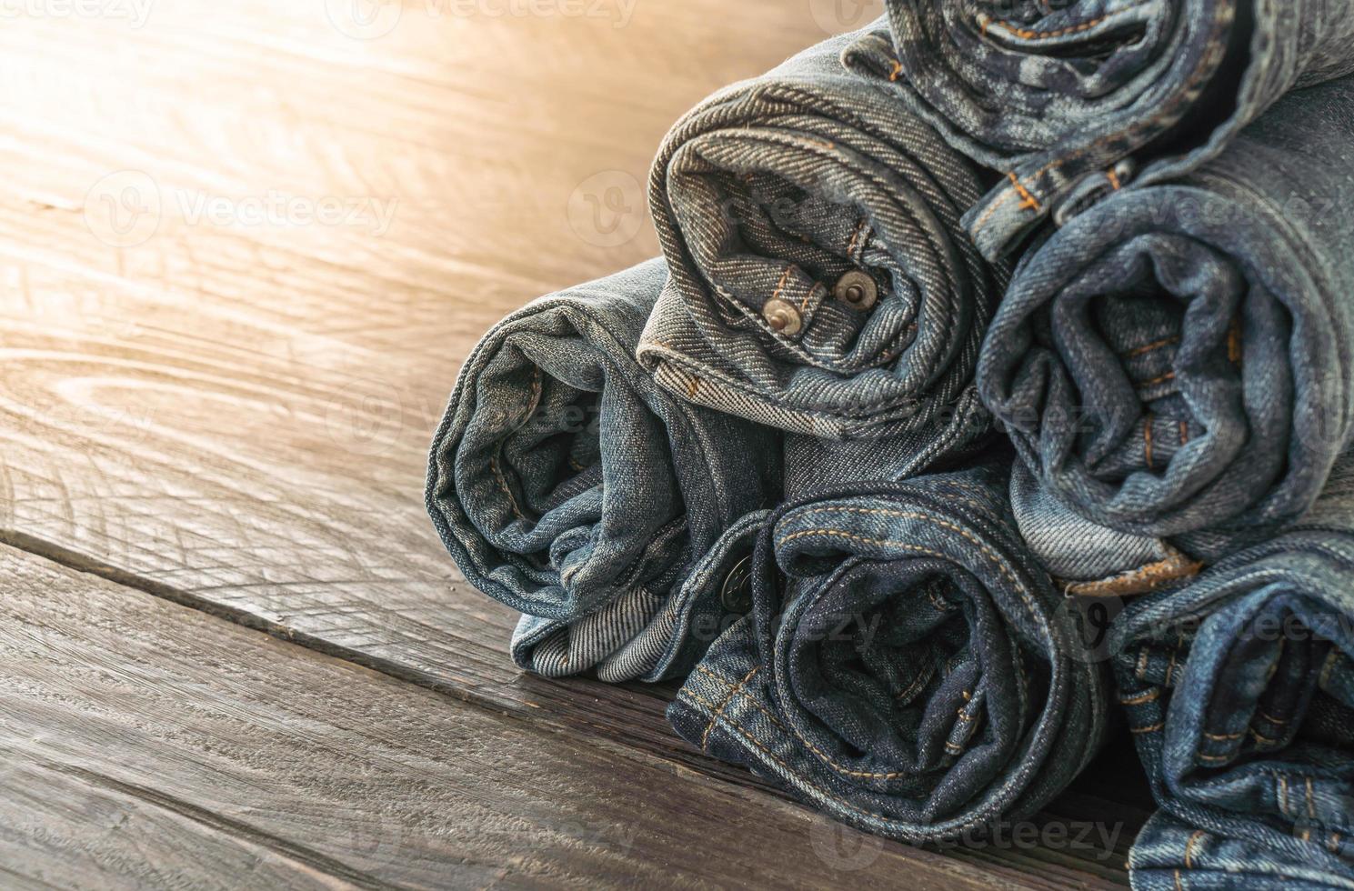 stapel jeans op houten vloer foto