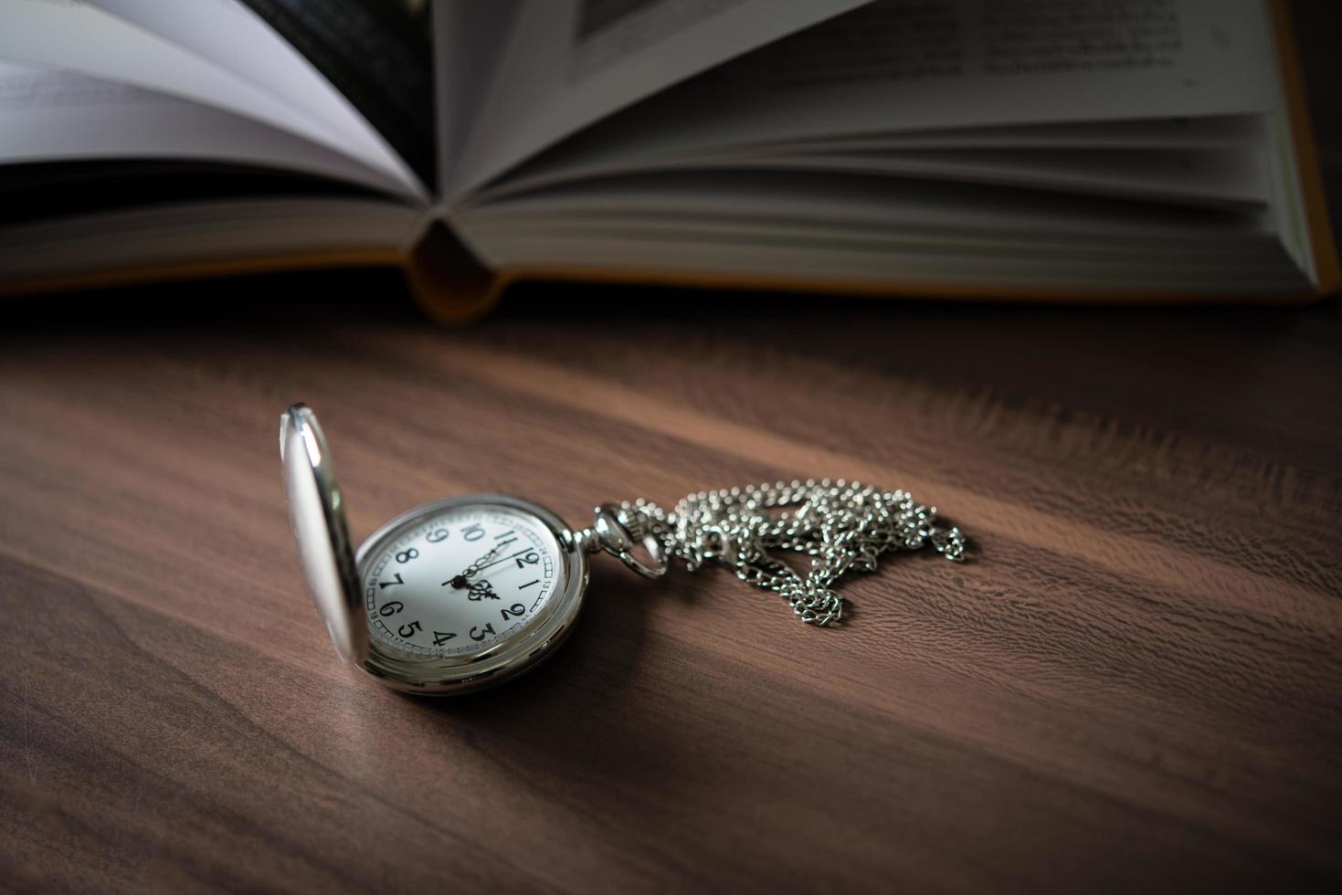 close-up van een gouden zakhorloge en een boek foto