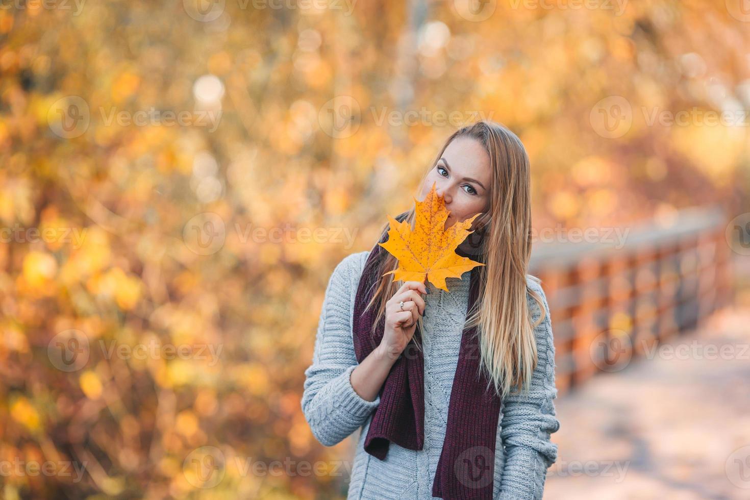 mooi vrouw in herfst park onder vallen gebladerte foto