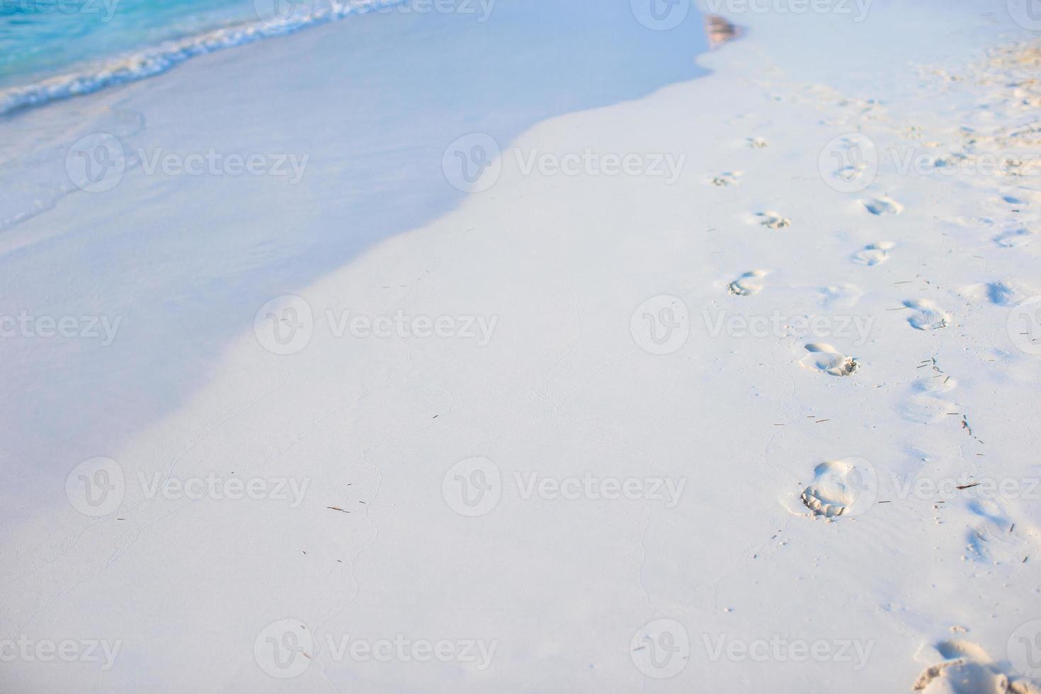 menselijk voetafdrukken Aan wit zand strand foto