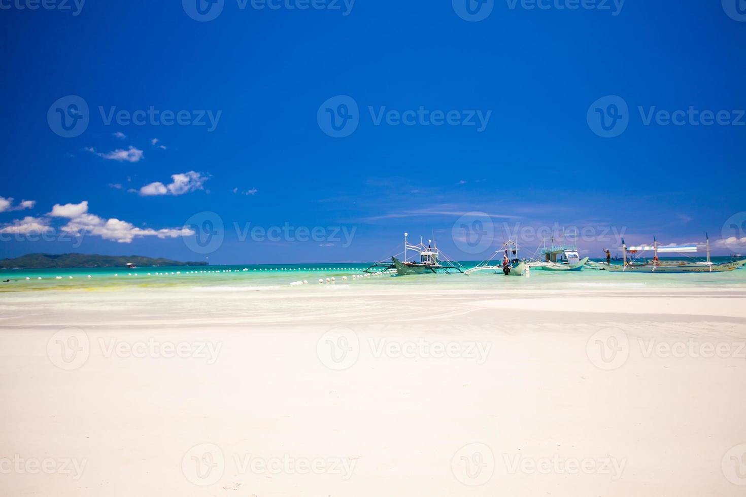 perfect tropisch strand met turkoois water en zeilboten foto