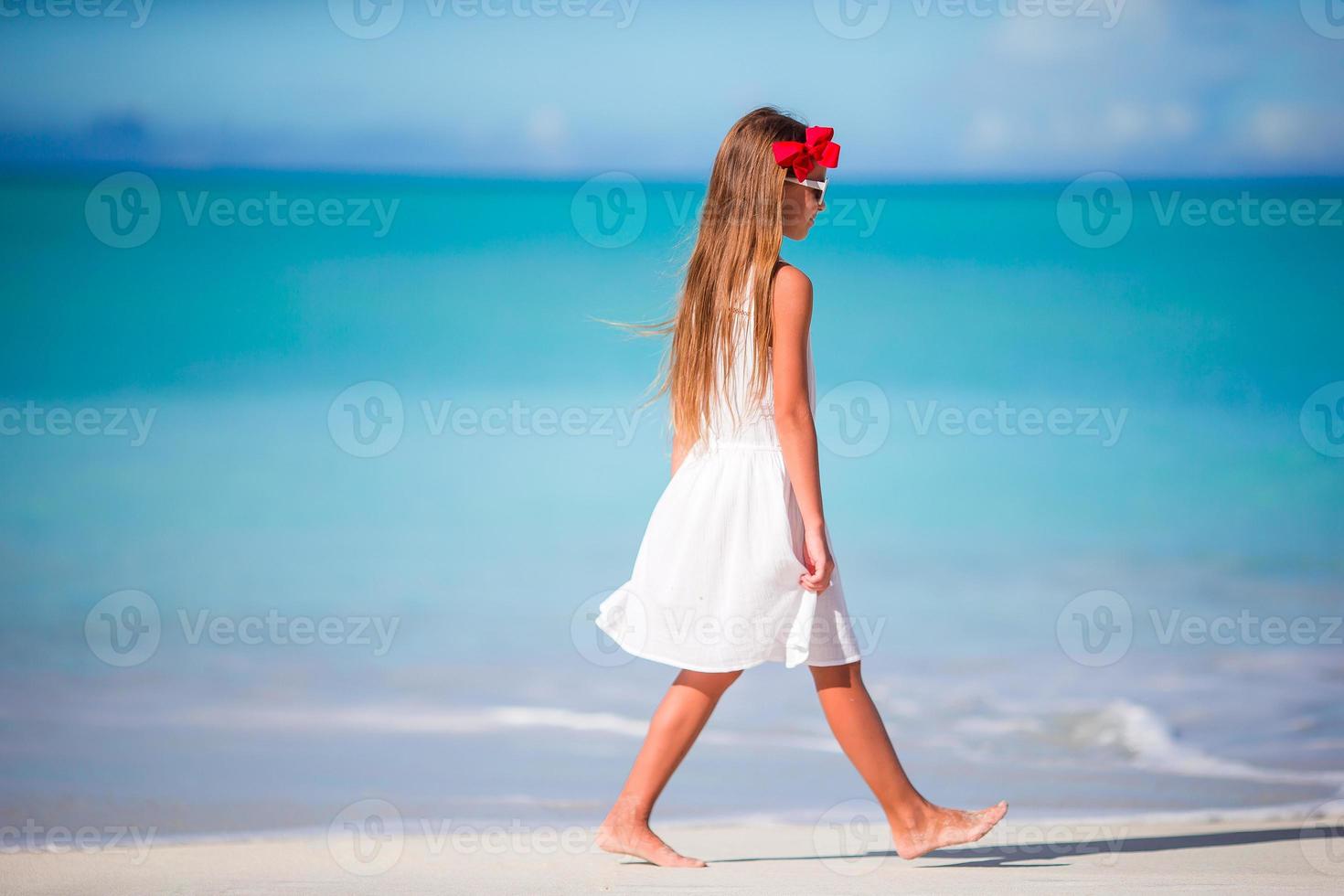 schattig weinig meisje Bij strand gedurende caraïben vakantie foto