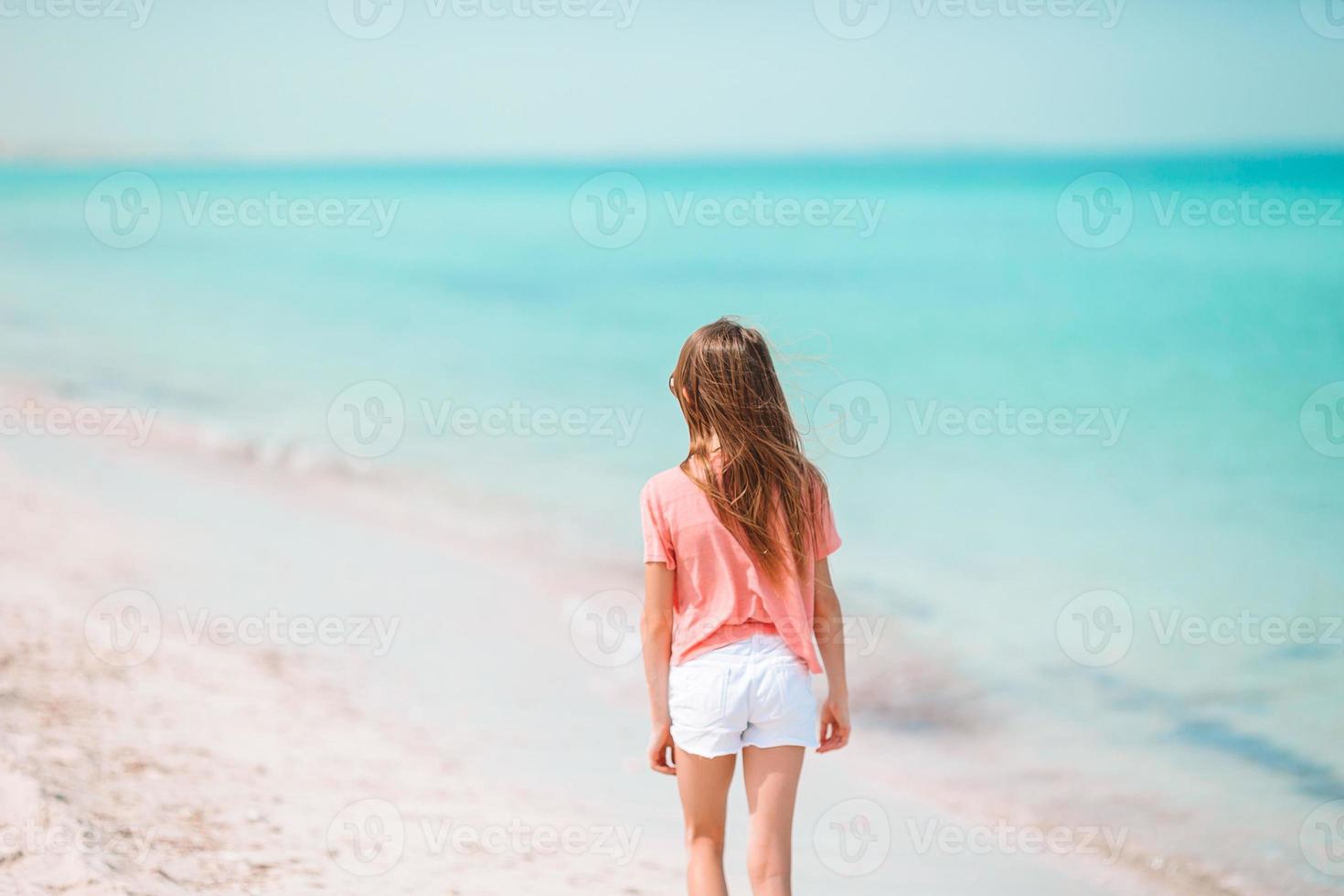 schattig klein meisje veel plezier op tropisch strand tijdens vakantie foto