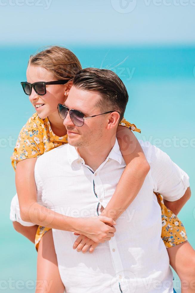 weinig meisje en gelukkig vader hebben pret gedurende strand vakantie foto