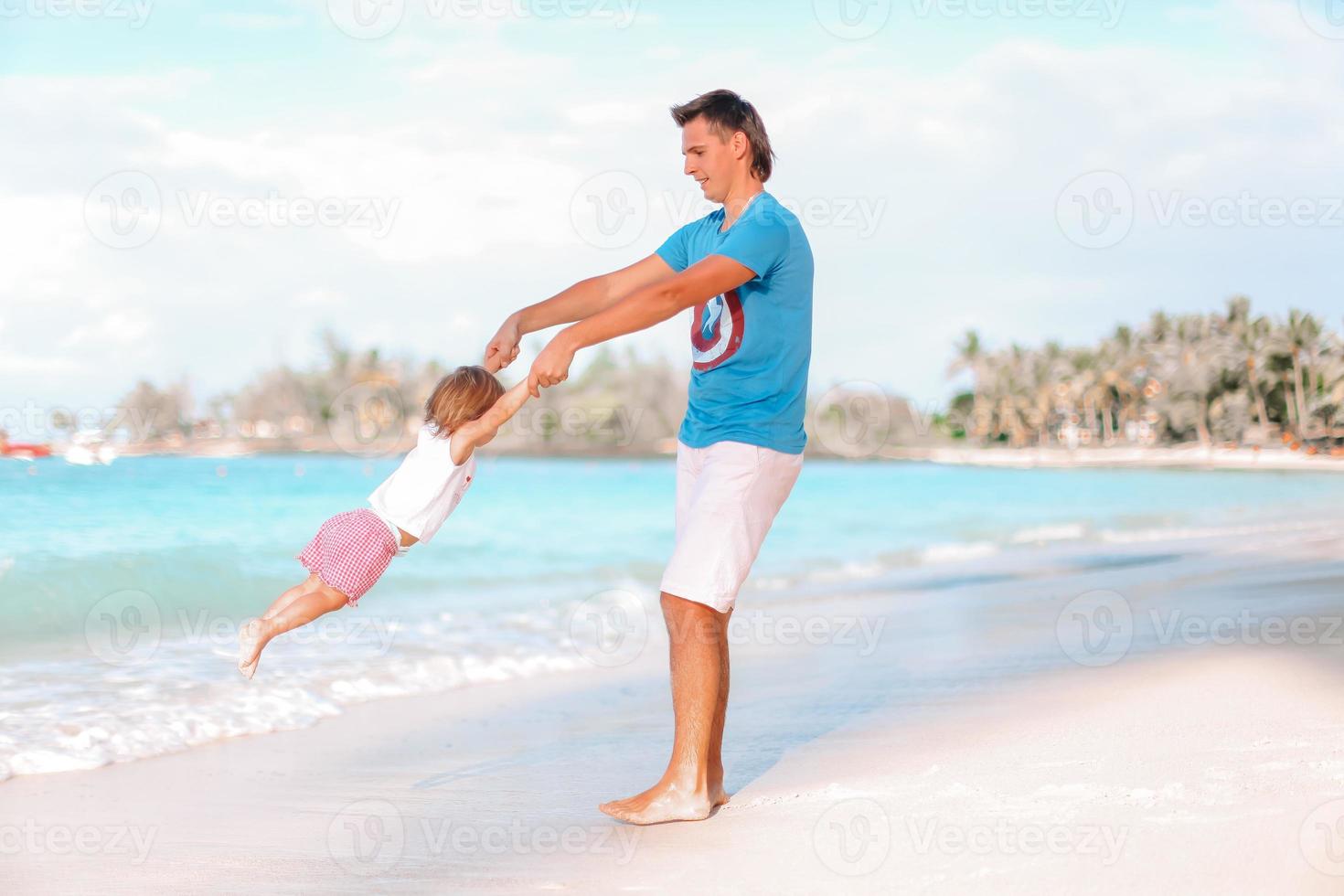 weinig meisje en gelukkig vader hebben pret gedurende strand vakantie foto