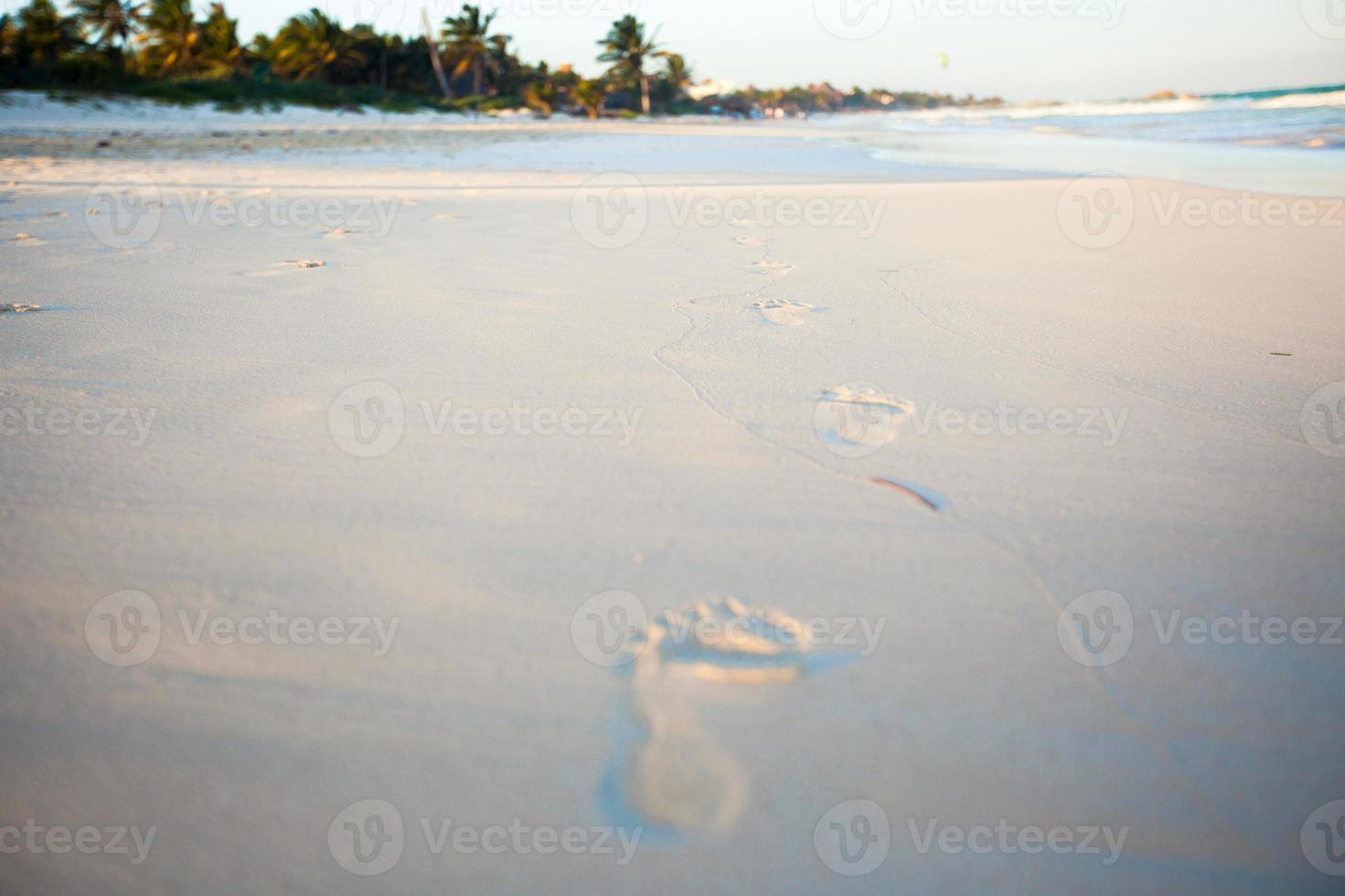 menselijk voetafdrukken Aan de wit zanderig strand foto