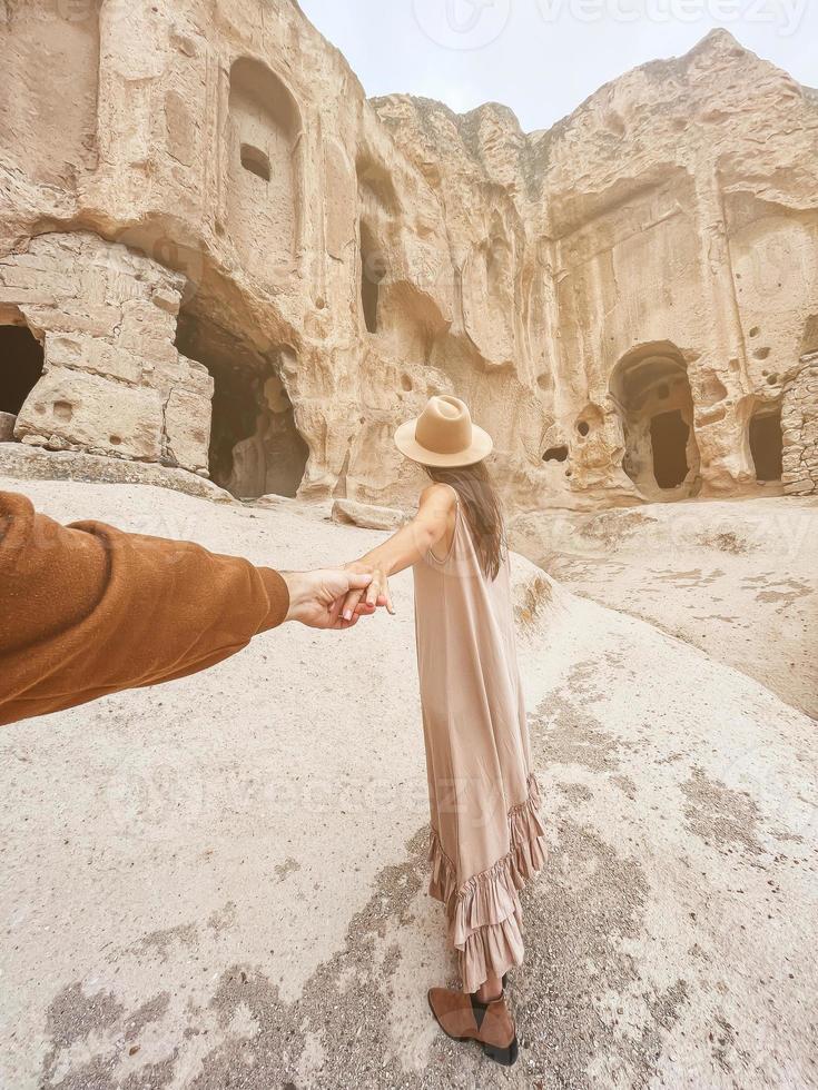 gelukkig jong vrouw Aan achtergrond van oude grot formaties in Cappadocië, kalkoen. de klooster is een van de grootste religieus gebouwen. foto