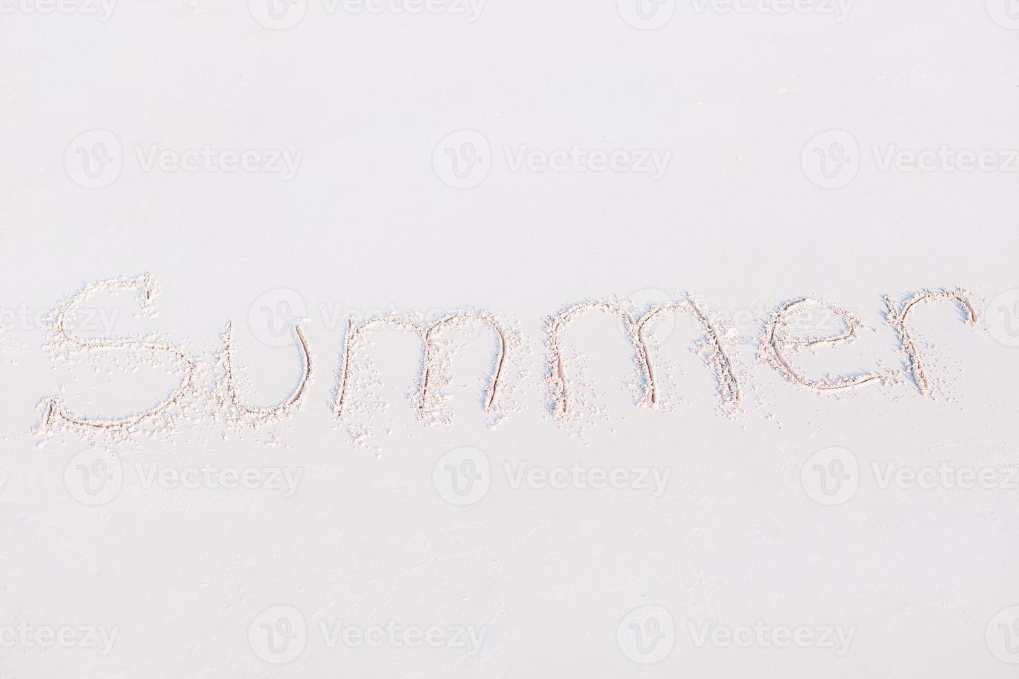 woord zomer handgeschreven Aan zanderig strand met zacht oceaan Golf Aan achtergrond foto