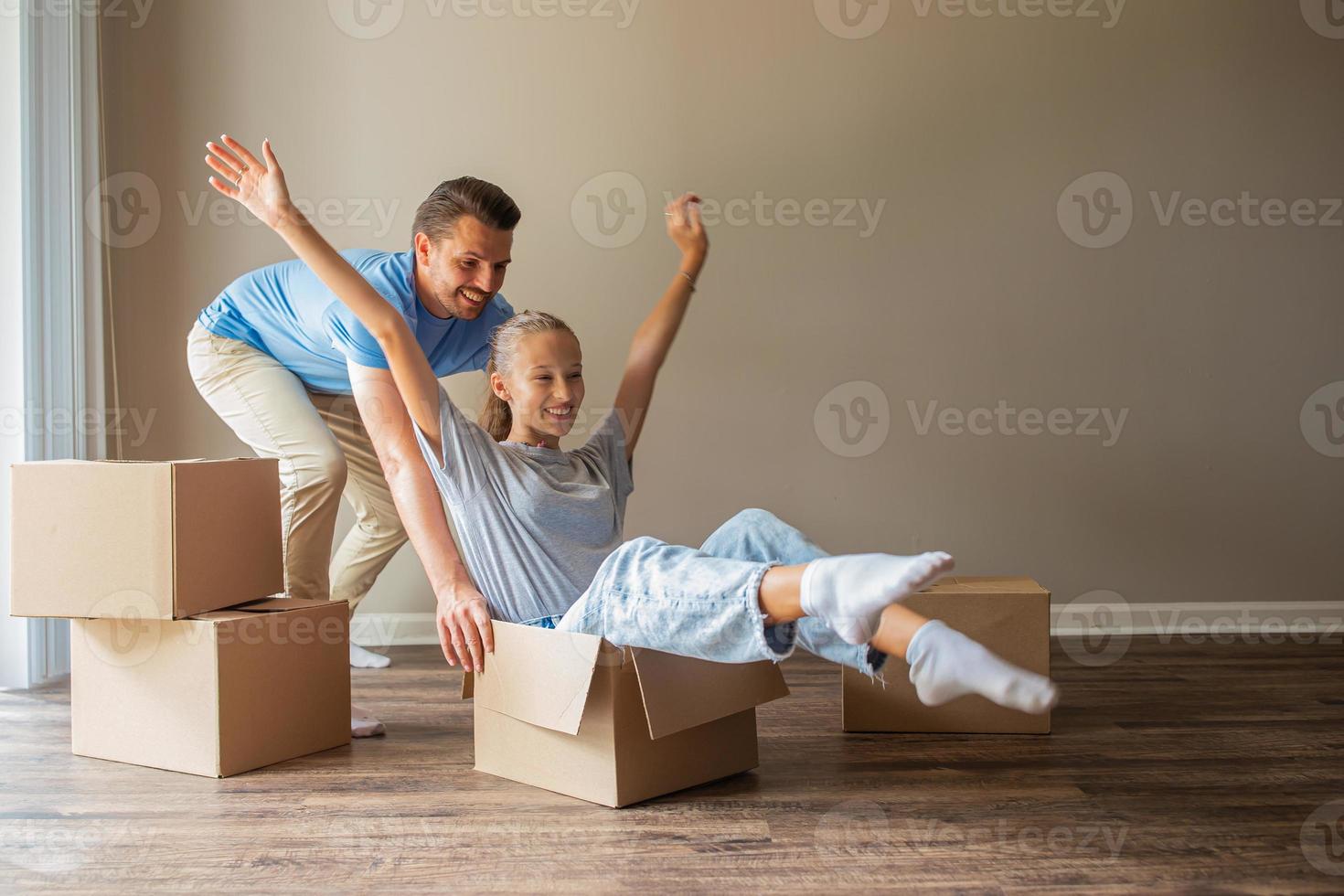 gelukkig vader met dochter hebben pret in hun nieuw huis. familie genieten hun in beweging dag foto