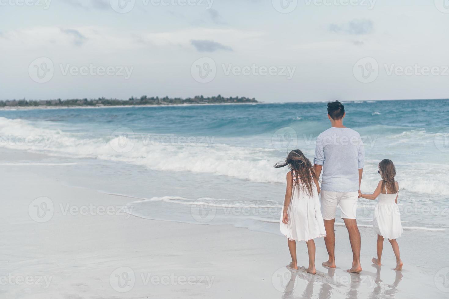 gelukkig mooi familie van vader en kinderen Aan wit strand foto