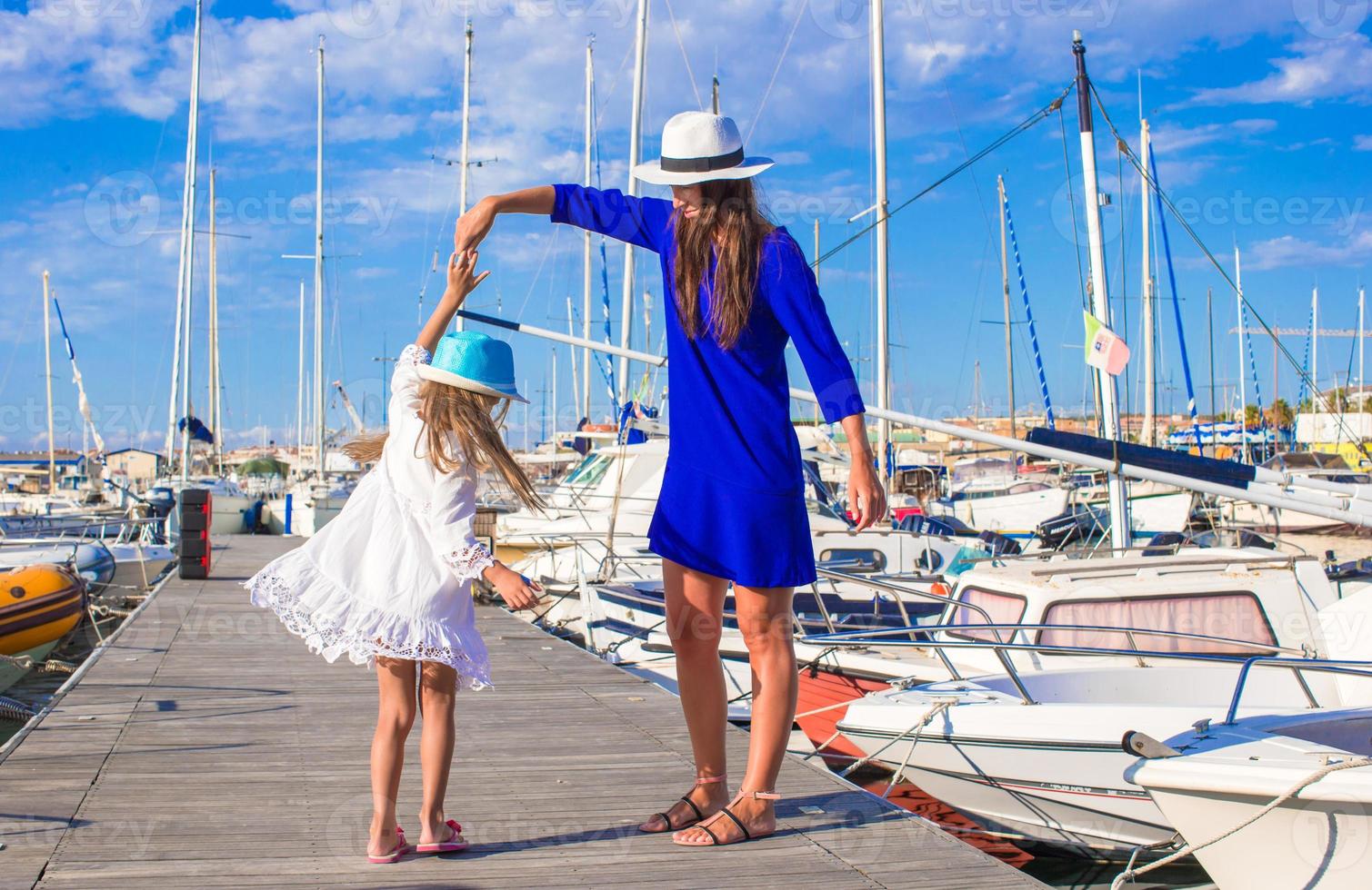 jong moeder en weinig meisje in haven gedurende zomer vakantie foto