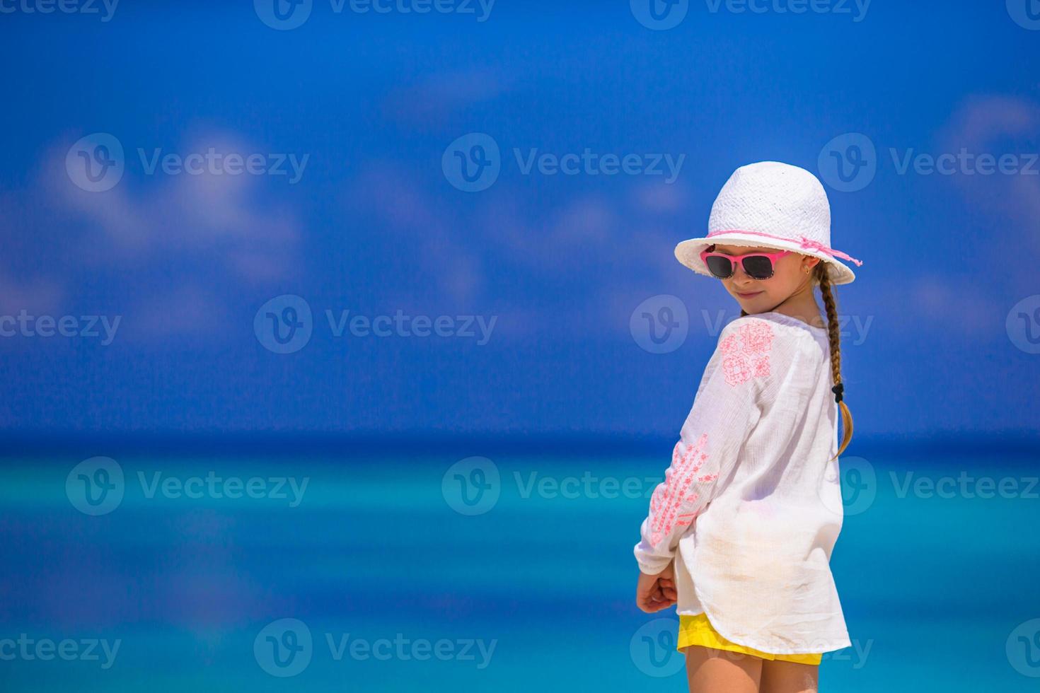 schattig klein meisje op het strand tijdens de zomervakantie foto