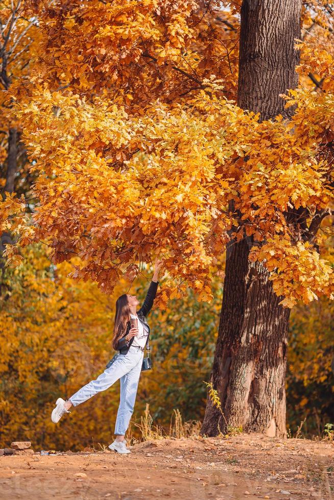 vallen concept - mooi vrouw in herfst park onder vallen gebladerte foto