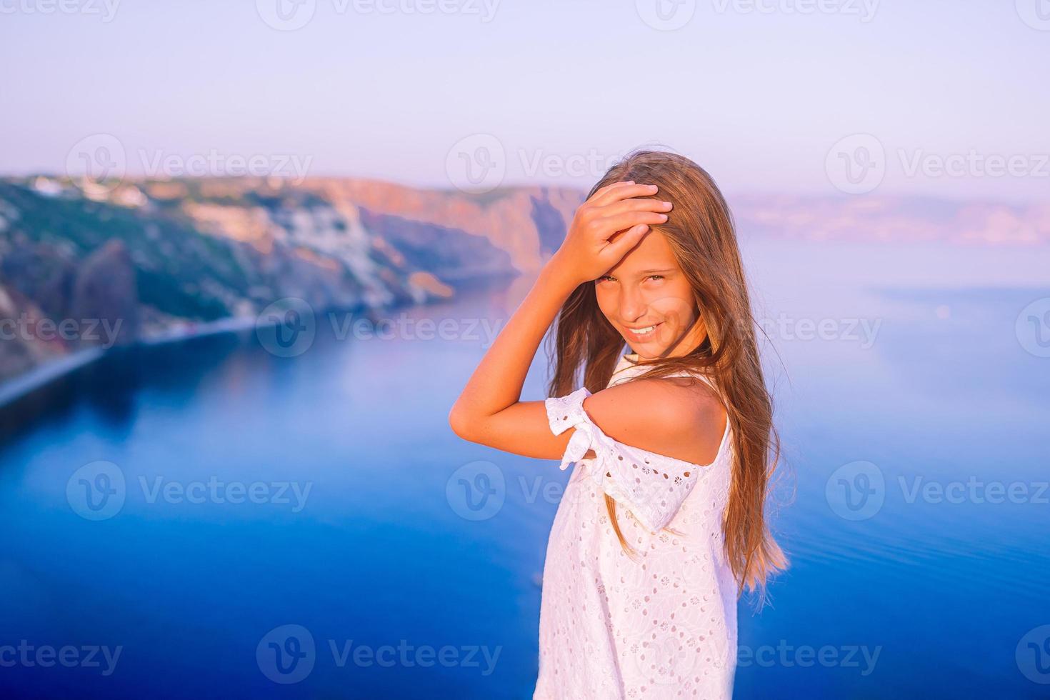 weinig meisje Aan top van een berg genieten van vallei visie voordat zonsondergang foto