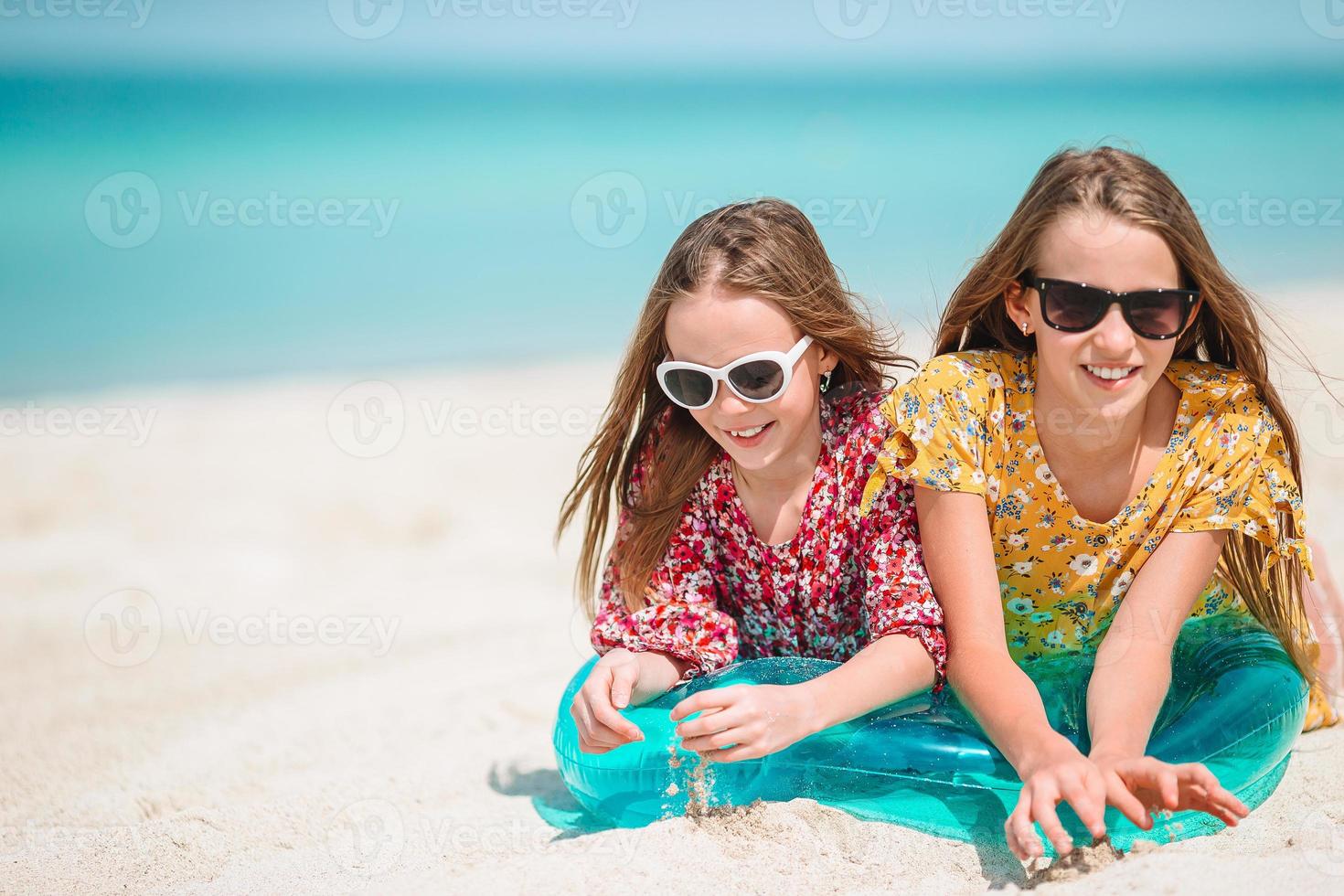 weinig gelukkig grappig meisjes hebben een veel van pret Bij tropisch strand spelen samen. foto