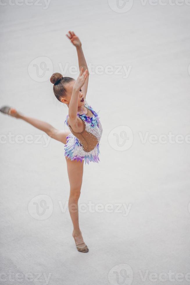 mooi weinig actief gymnast meisje met haar prestatie Aan de tapijt foto