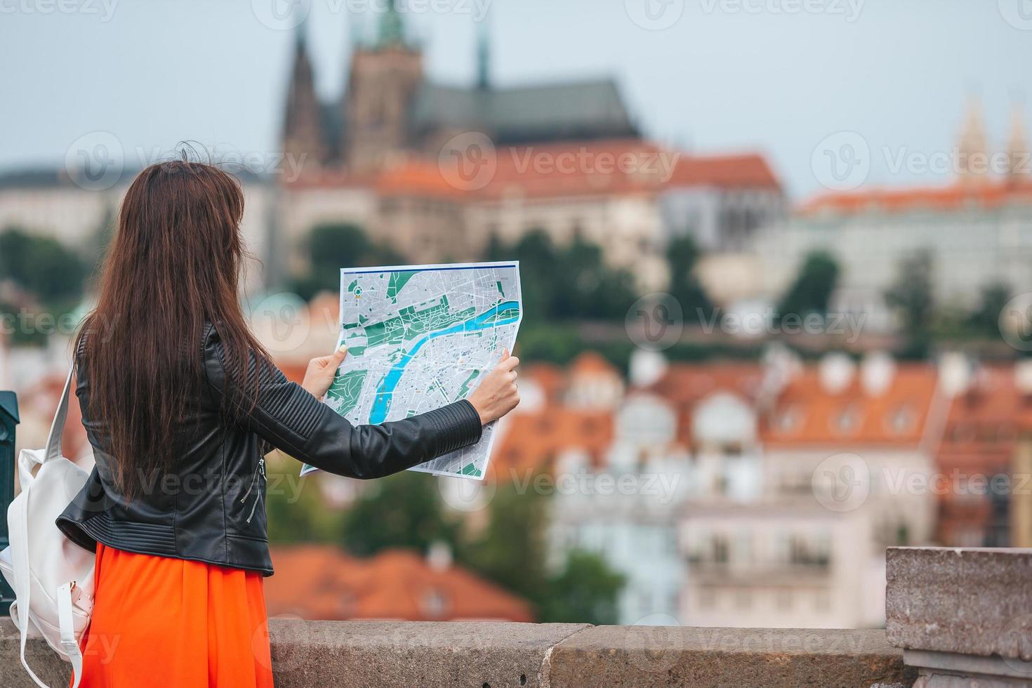 gelukkig jong vrouw met een stad kaart in stad. reizen toerist vrouw met kaart buitenshuis gedurende vakantie in Europa. foto