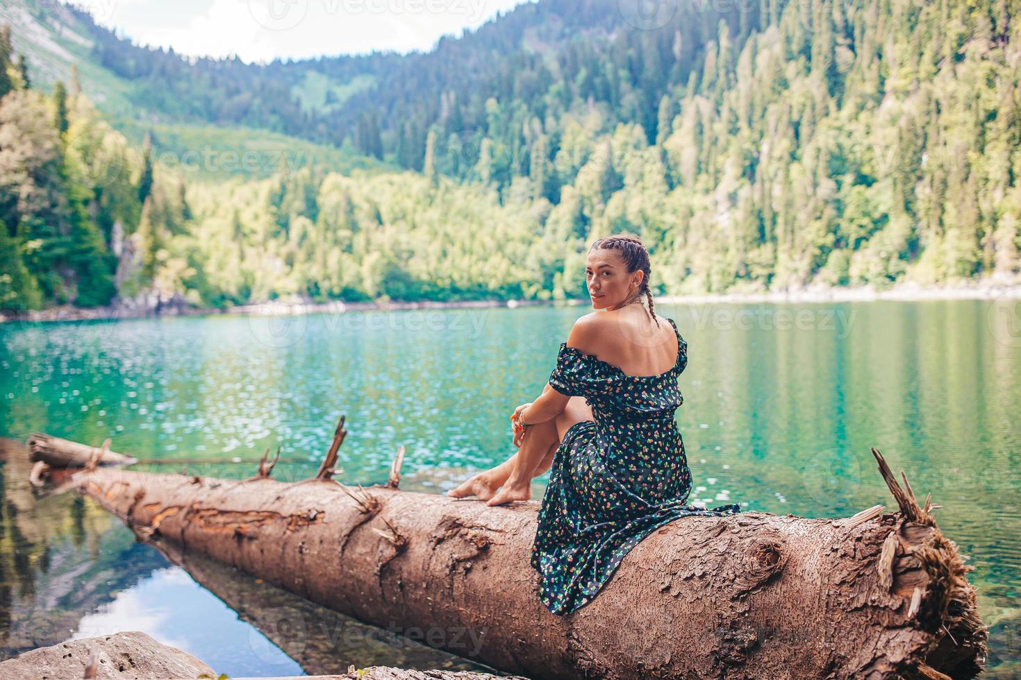 gelukkig romantisch vrouw zittend door meer spatten water foto