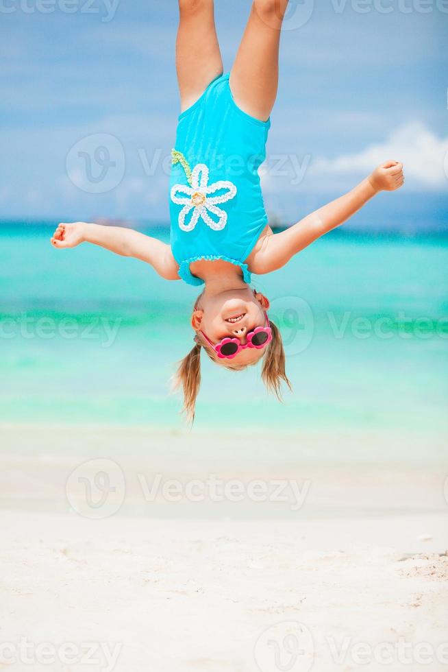 weinig meisje en gelukkig vader hebben pret gedurende strand vakantie foto