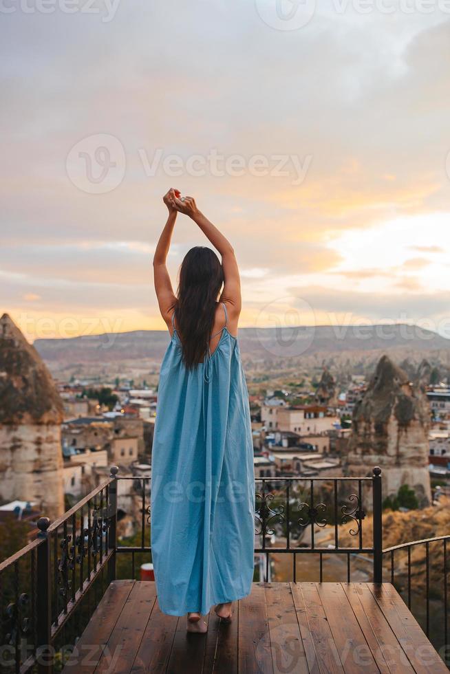 gelukkig jong vrouw gedurende zonsopkomst aan het kijken heet lucht ballonnen in Cappadocië, kalkoen foto