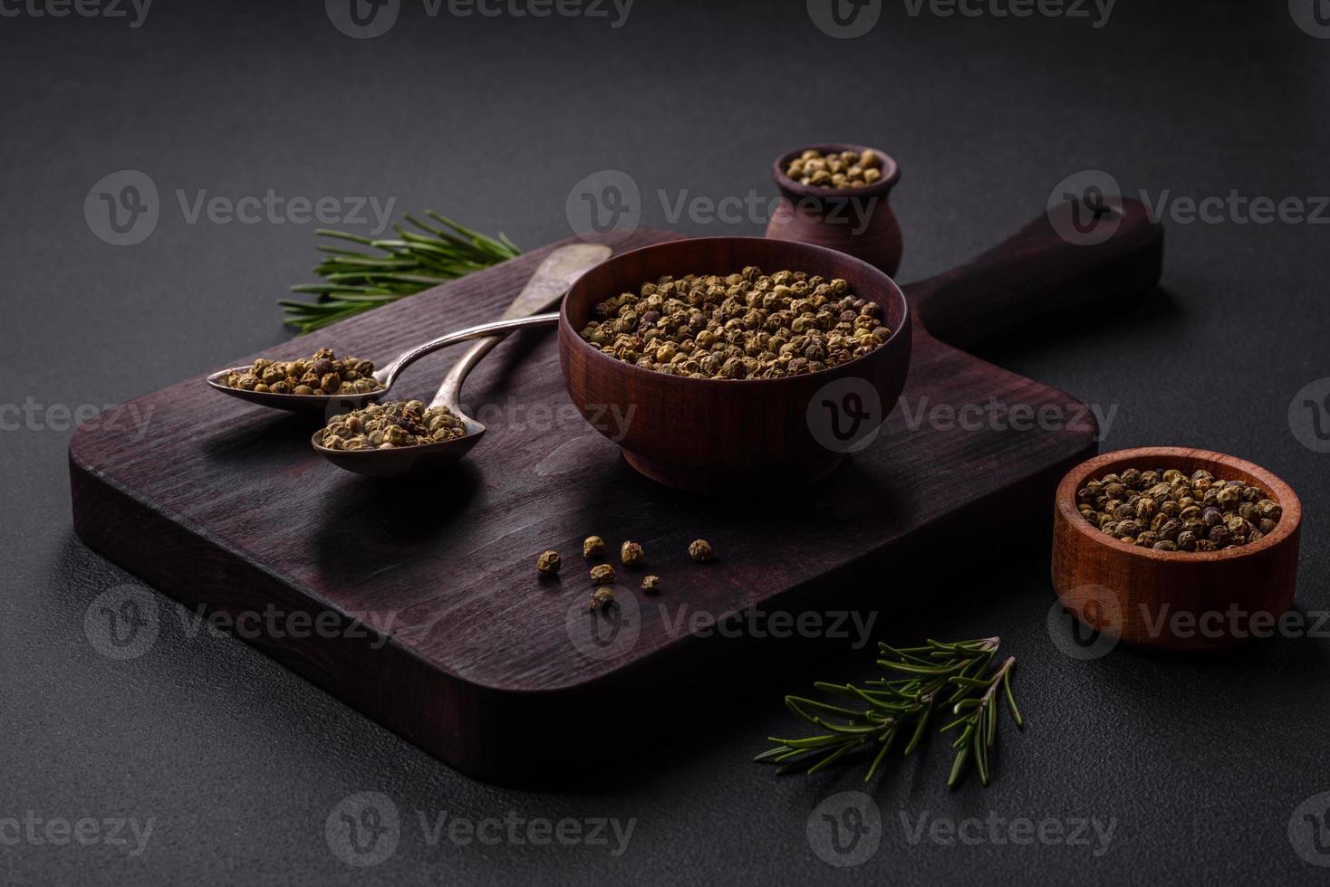 kruid, piment groen in een houten kom Aan een zwart beton achtergrond foto