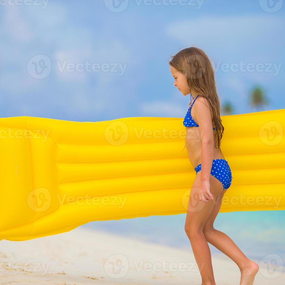 aanbiddelijk gelukkig meisje met opblaasbaar lucht matras Aan wit strand foto