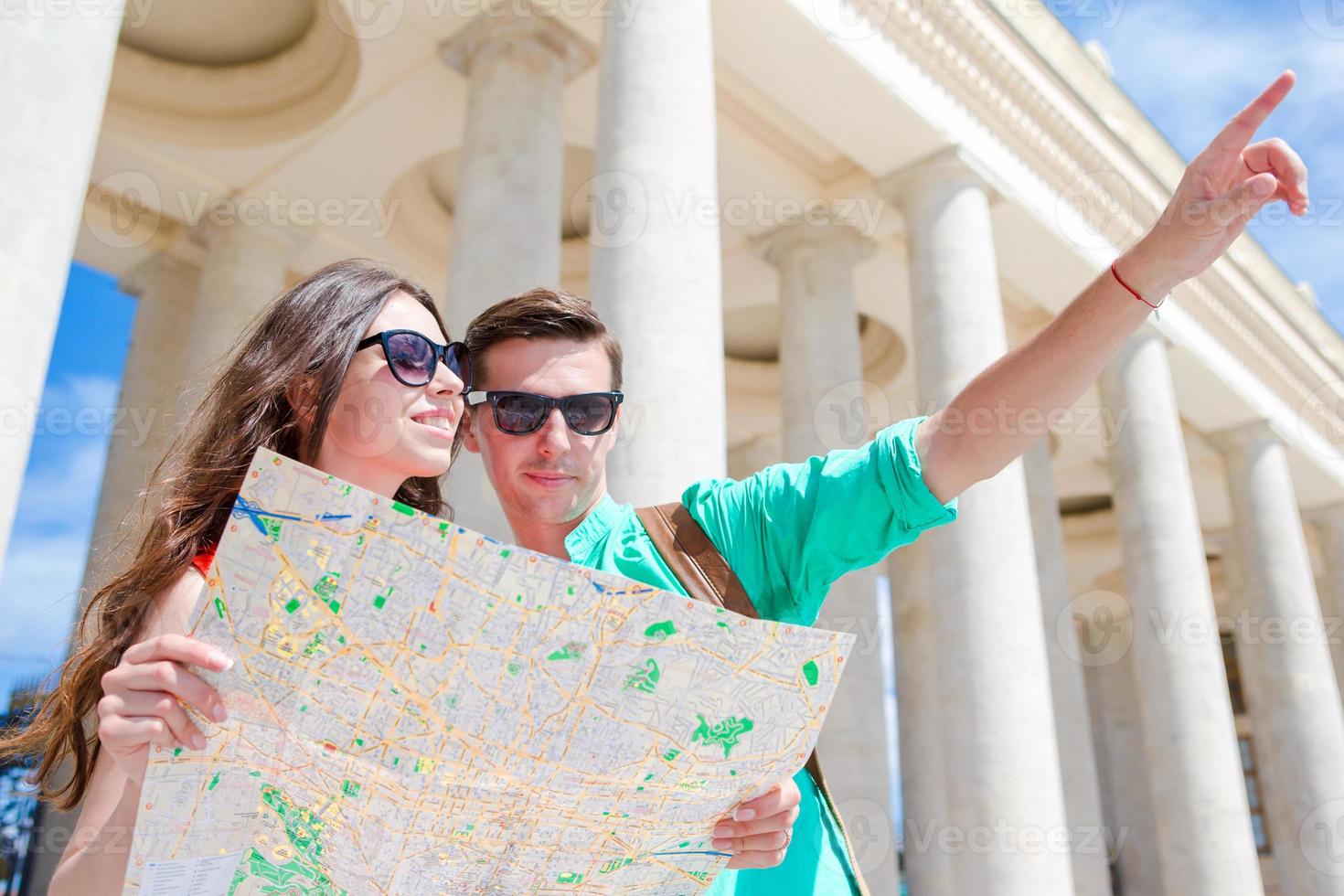 jong toerist vrienden op reis Aan vakantie in Europa glimlachen gelukkig. Kaukasisch familie met stad kaart in zoeken van attracties foto
