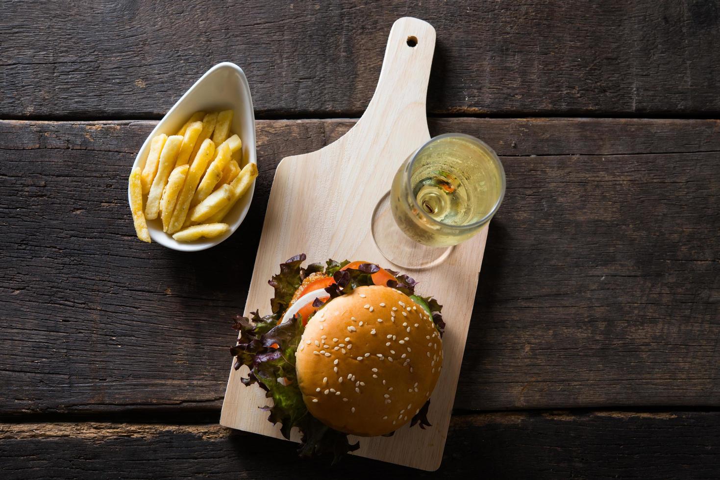 huisgemaakte kipburger met champagne en frietjes foto