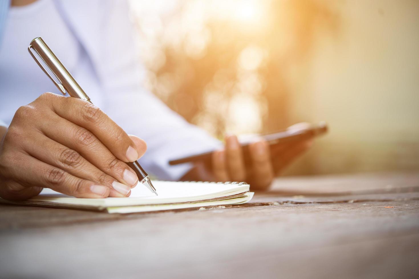 vrouw schrijven in notitieblok foto