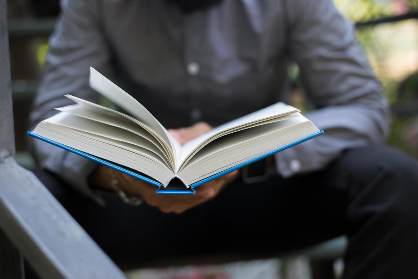 jonge man lezen van boeken in eigen tuin met de natuur foto