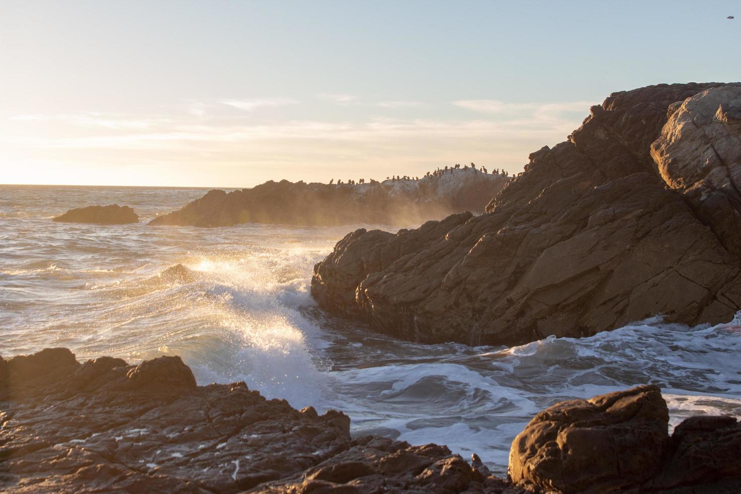 golven die tegen rotsen bij een strand beuken foto