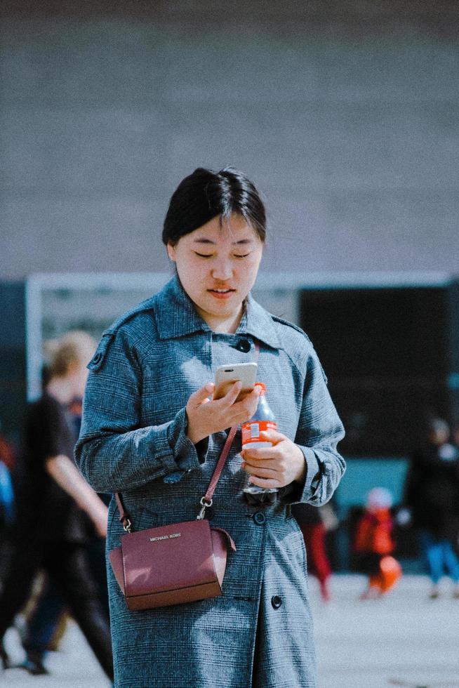 vrouw die met haar telefoon loopt foto