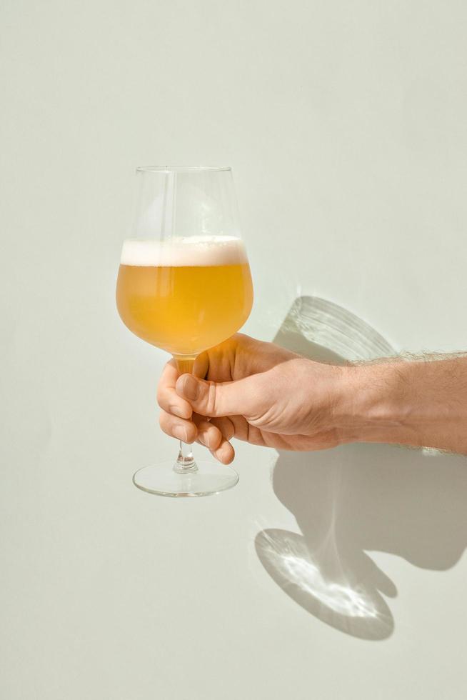 hand met een glas bier foto