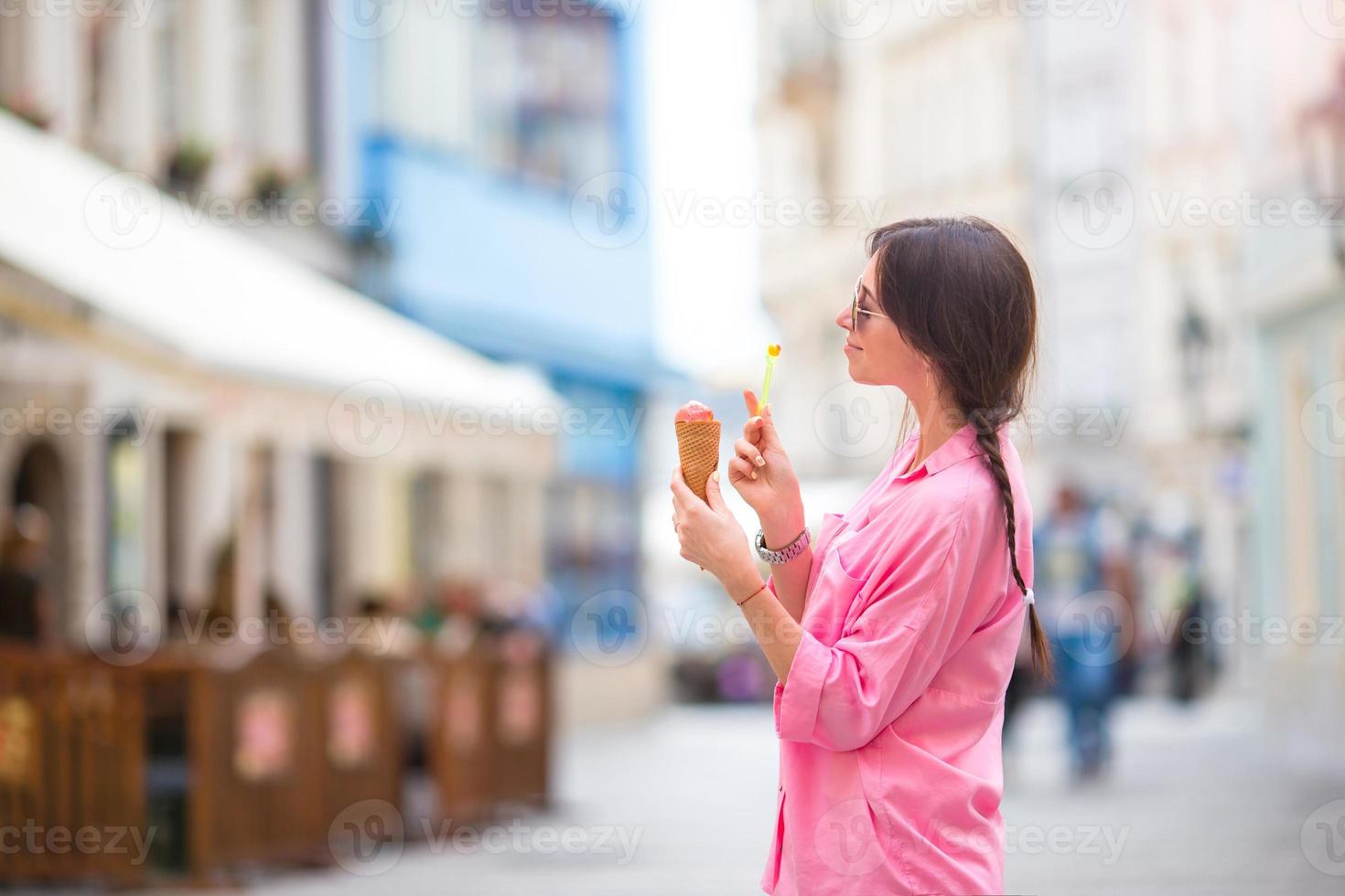 jong vrouw model- aan het eten ijs room ijshoorntje buitenshuis. zomer concept - vrouw met zoet ijsje Bij heet dag foto