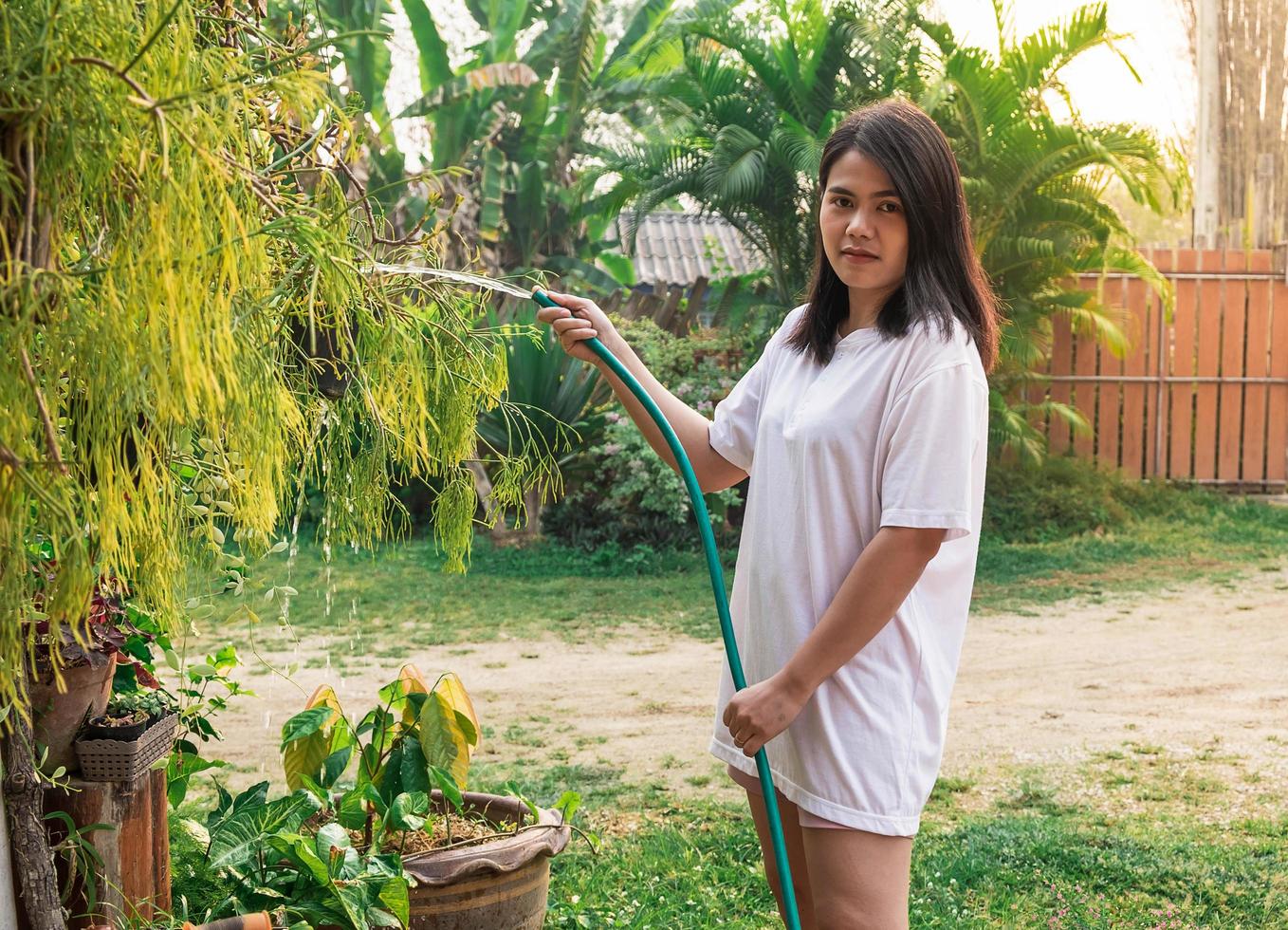 vrouw buiten planten water geven foto