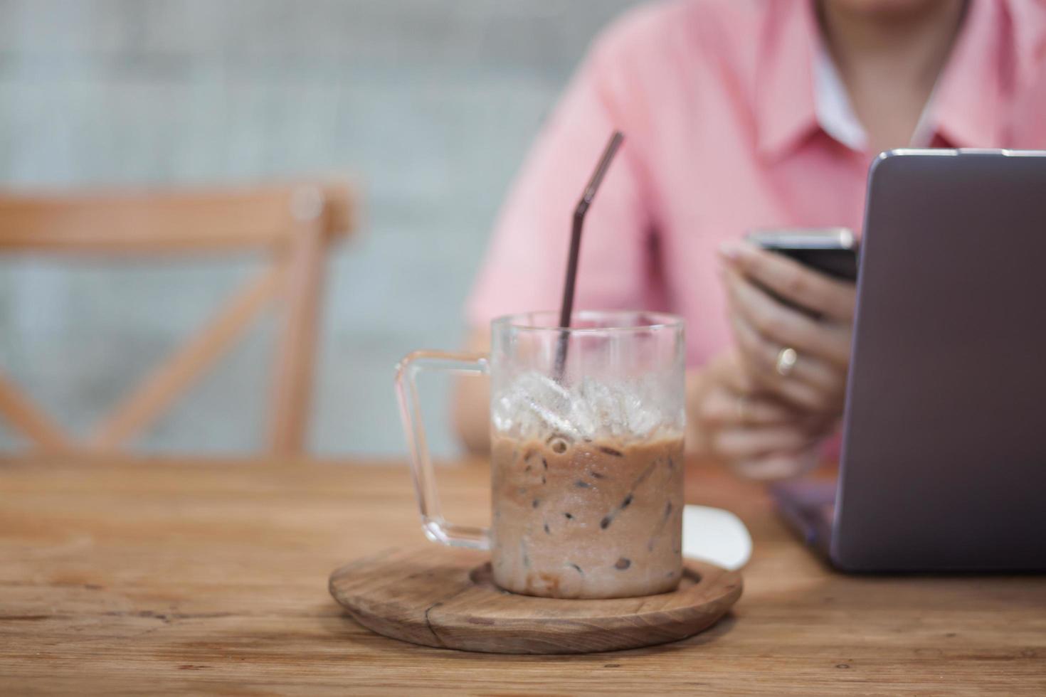 ijskoffie in een coffeeshop met een werkende vrouw foto