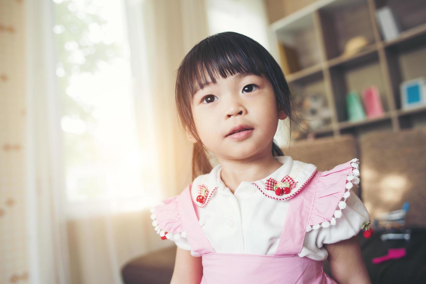 portret van een klein Aziatisch meisje speelt in haar huis foto