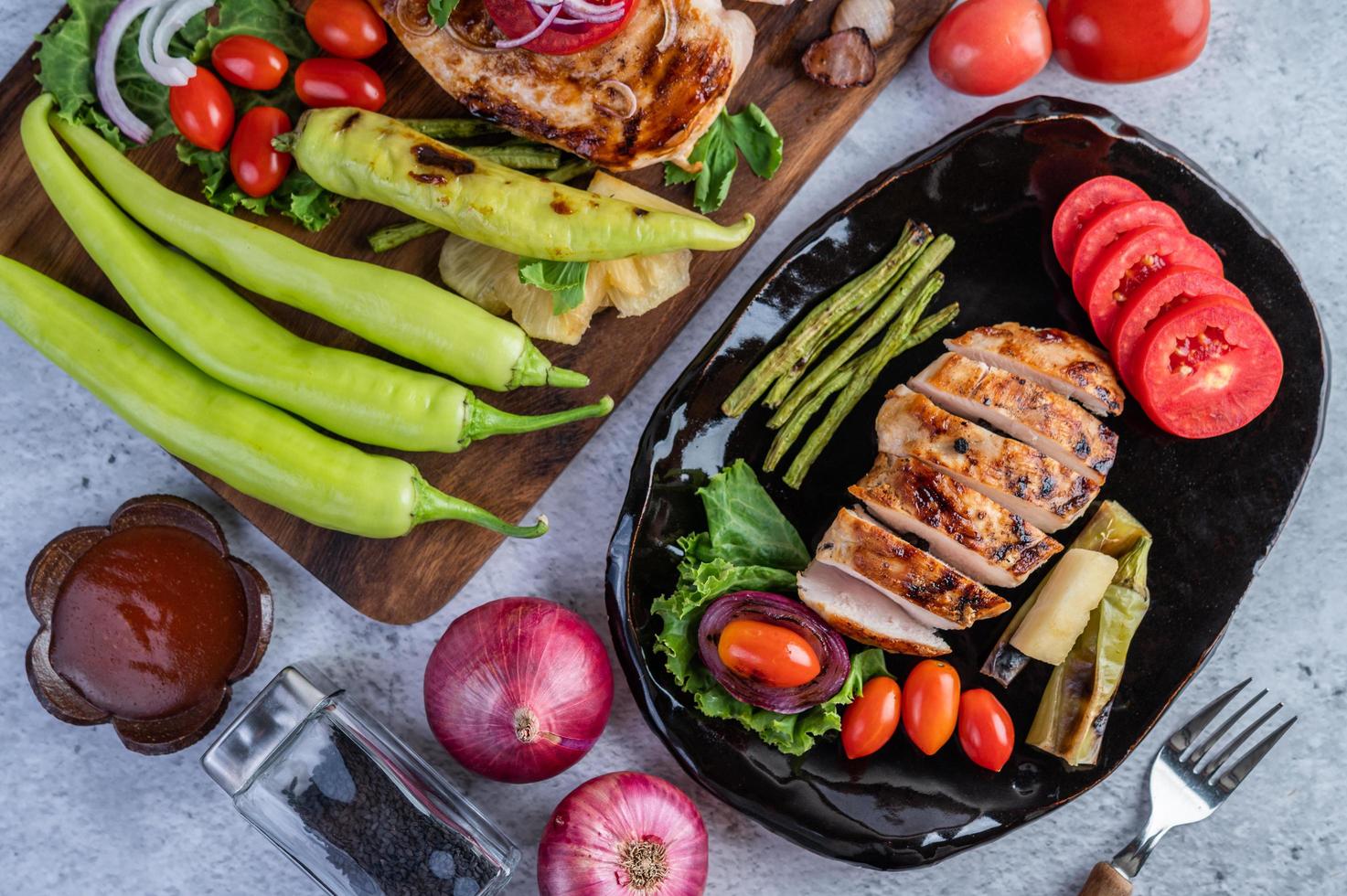 kippenbiefstuk met salade groenten op een zwarte plaat foto