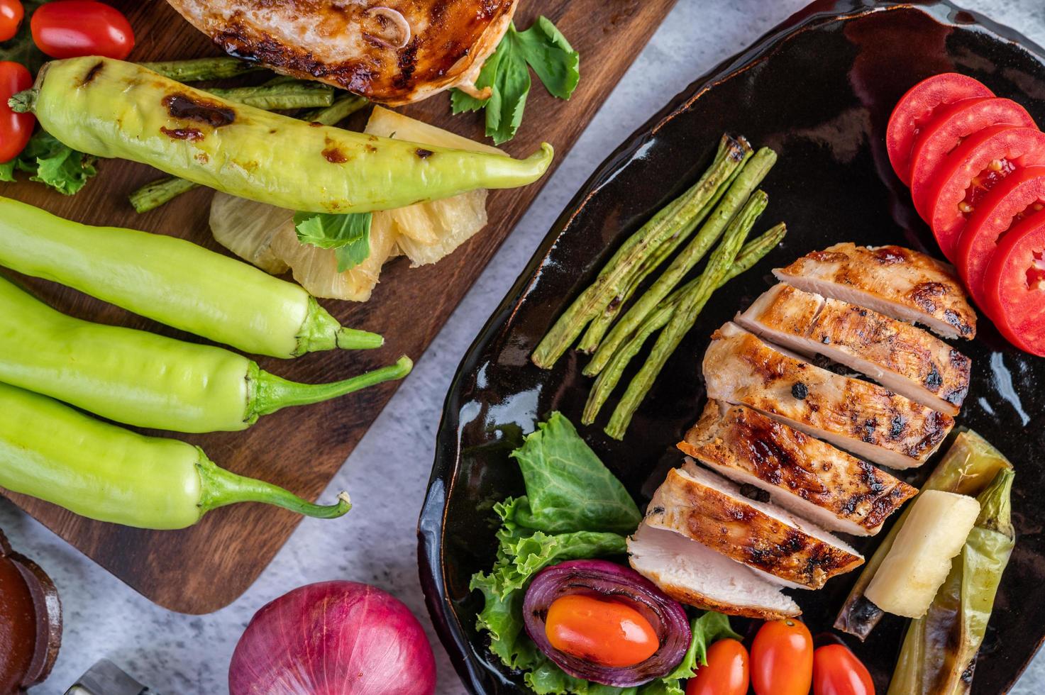 kippenbiefstuk met salade groenten op een zwarte plaat foto