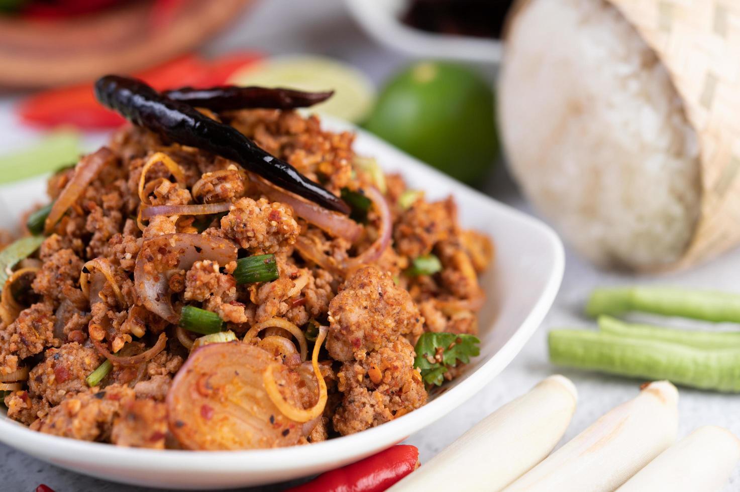 een bord met gehakt varkensvlees met ingrediënten foto