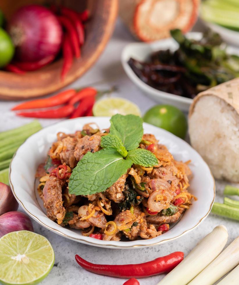 een bord met gehakt varkensvlees met ingrediënten foto